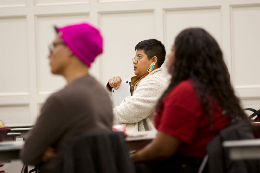 Three students listen to a lecture.