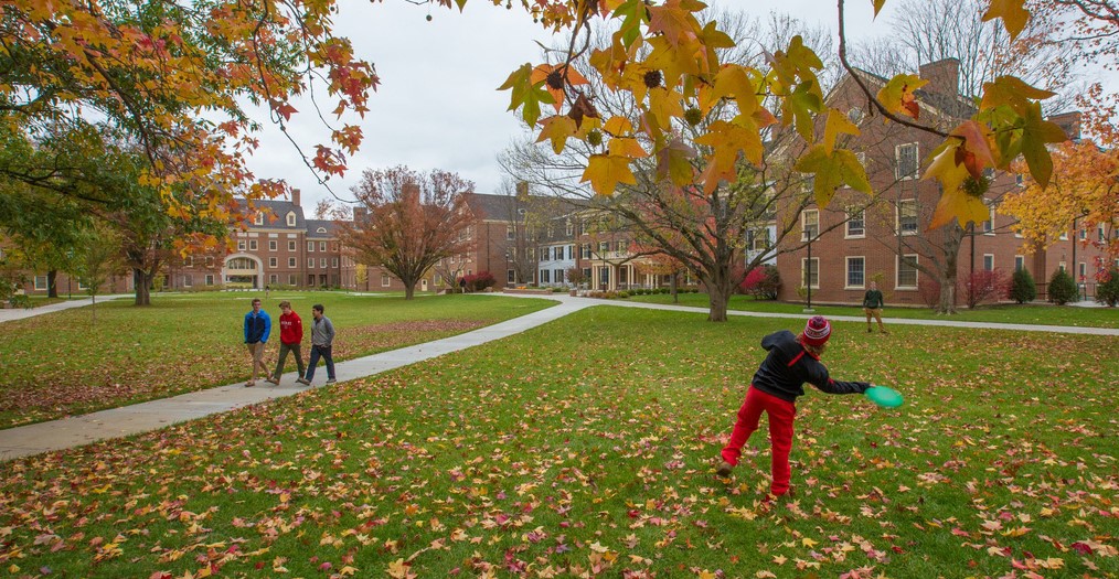 Students throwing a frisbee outside of their residence hall