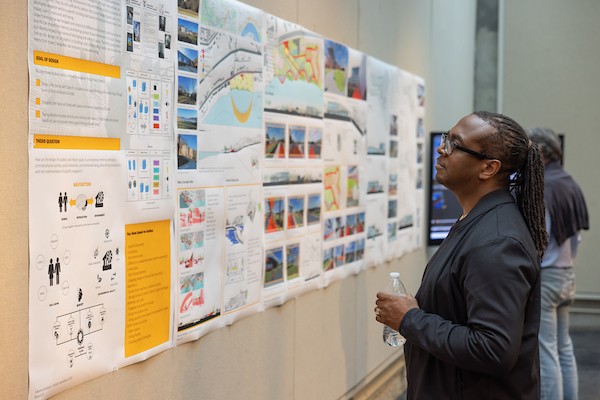 A large format printed poster being viewed by attendees at an event