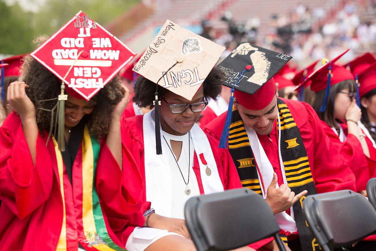 Graduating students with first gen decorated on their mortarboards