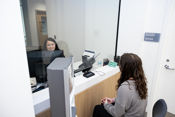Student checks in at the clinic front desk for a doctor’s appointment.