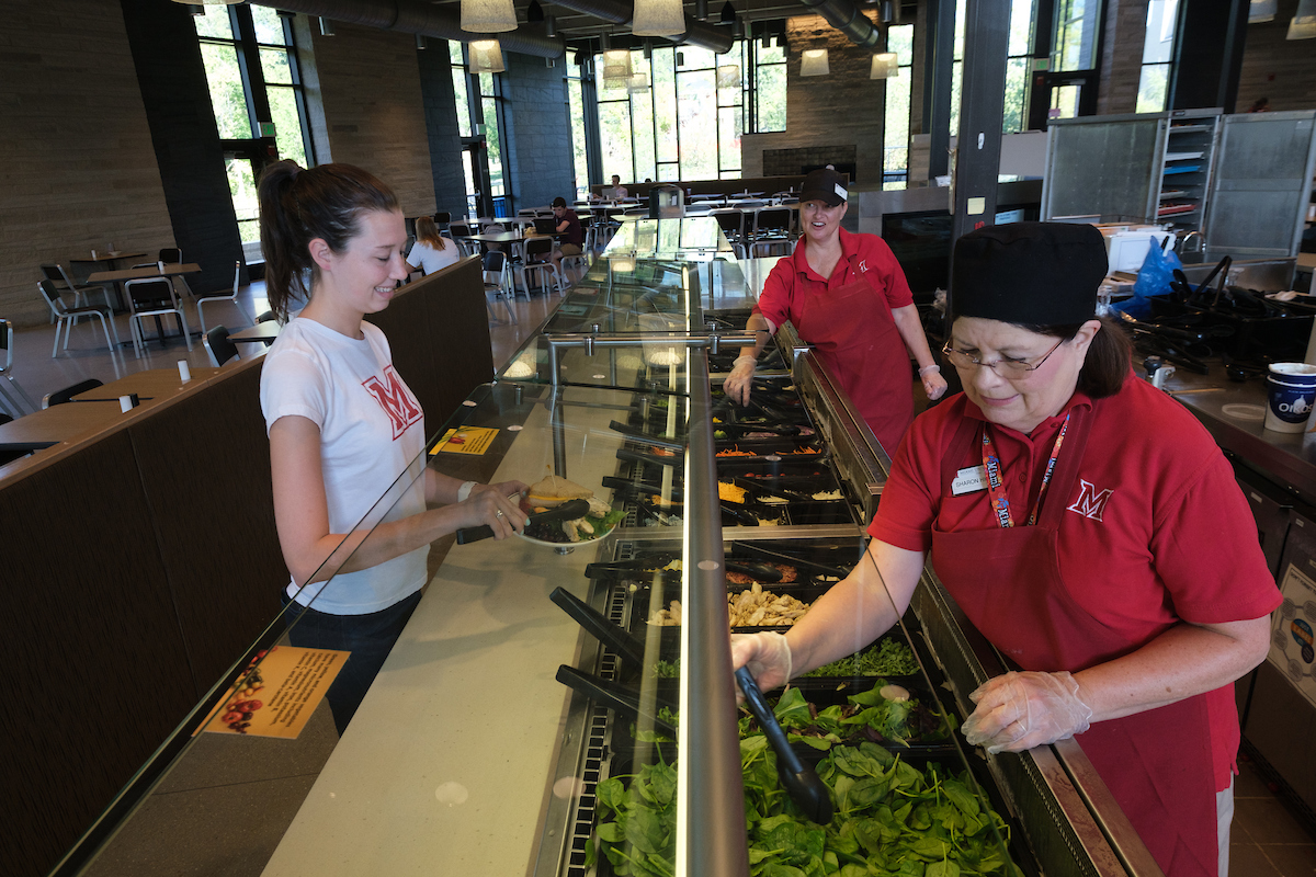 female student going through line in a dining hall