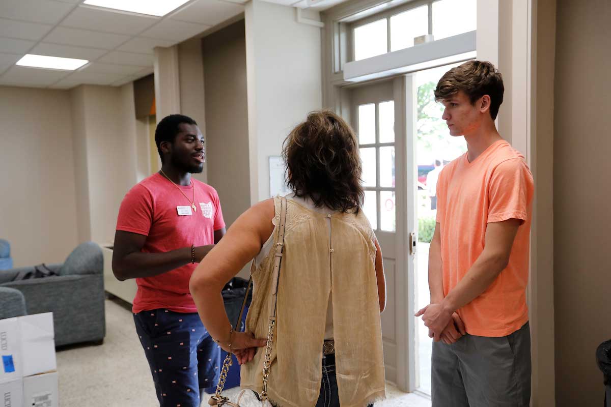 Resident Assistant speaking with a parent and student