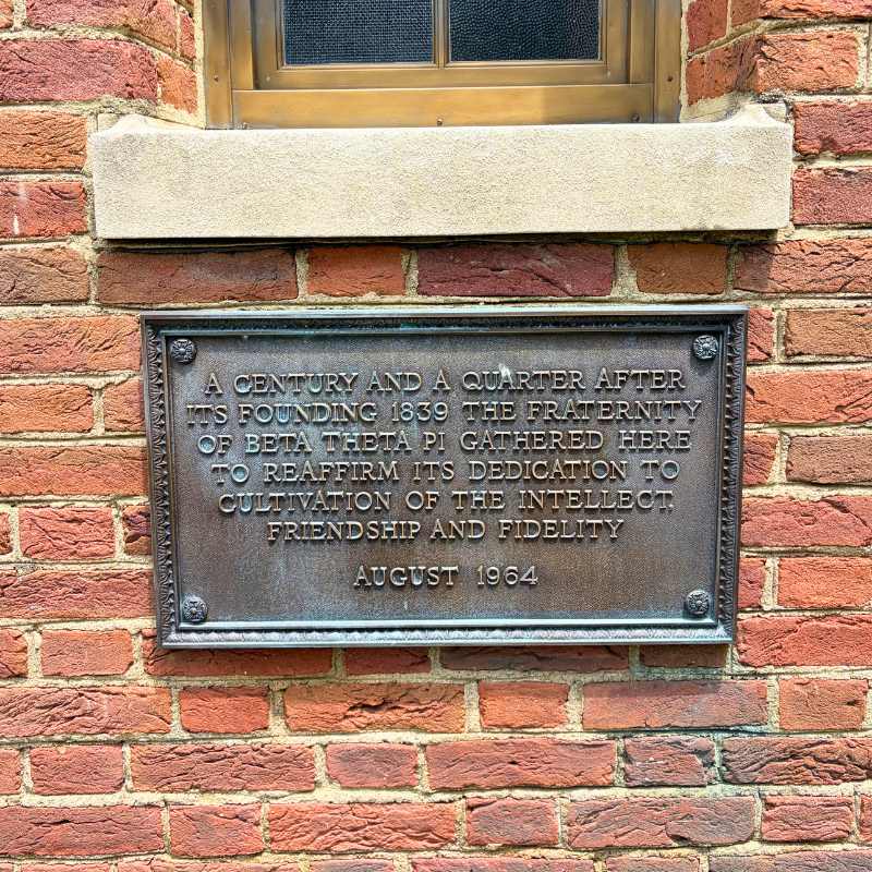 Plaque that reads a century and a quarter after its founding 1839 the fraternity of beta theta pi gathered here to reaffirm its dedication to cultivation of the intellect, friendship and fidelity. August 1964.