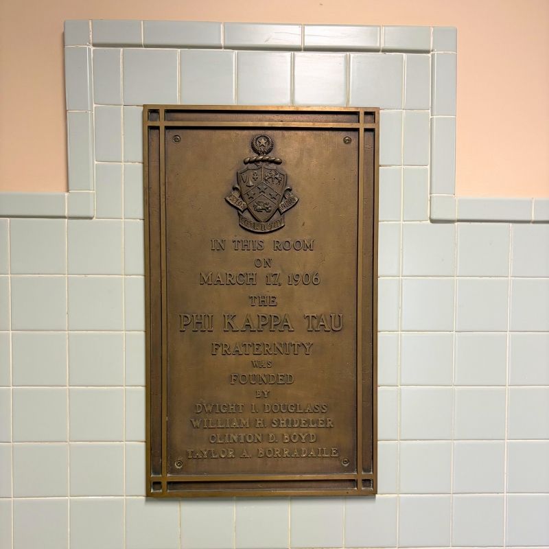 Plaque that reads In this room on March 17, 1906, the Phi Kappa Tau Fraternity was founded by Dwight I. Douglass, William H. Shideler, Clinton D. Boyd and Taylor A. Borradail.