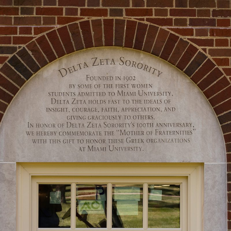 An arched brick outline surrounding the words etched in concrete: Delta Zeta Sorority. Founded in 1902 by some of the first women students admitted to Miami University, Delta Zeta holds fast to the ideals of insight, courage, faith, appreciation, and giving graciously to others. In honor of Delta Zeta Sorority's 100th anniversary, we hereby commemorate the "mother of Fraternities" with this gift to honor these Greek organizations at Miami University.