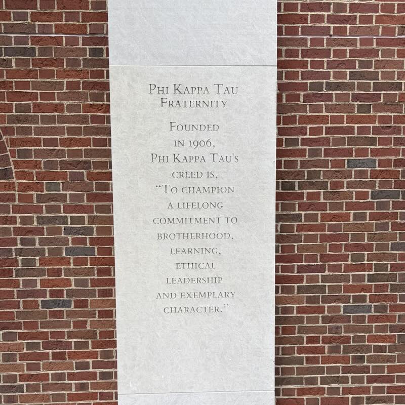 Concrete column with words etched: Phi Kappa Tau Fraternity. Founded in 1906, Phi Kappa Tau's creed is, "To champion a lifelong commitment to brotherhood, learning, ethical leadership and exemplary character."