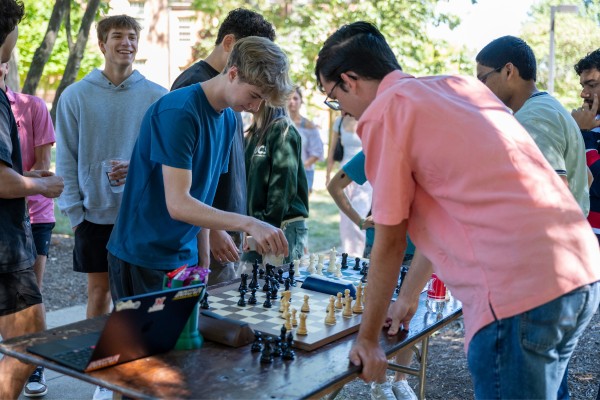 Students playing chess at a table at Mega Fair.