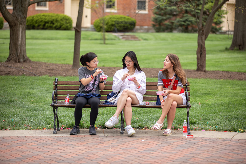 students eating on bench talking