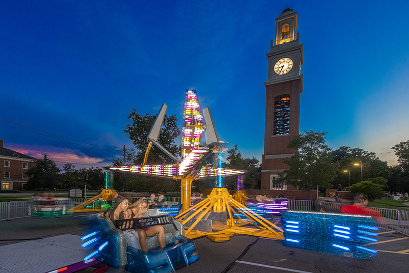 students on ride during event in front of bell tower