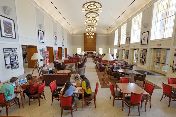 Students study on circles of couches in the brightly lit Shade Family Room