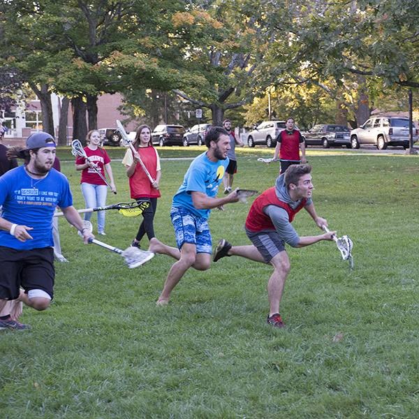 Miami students playing lacrosse on a grassy field