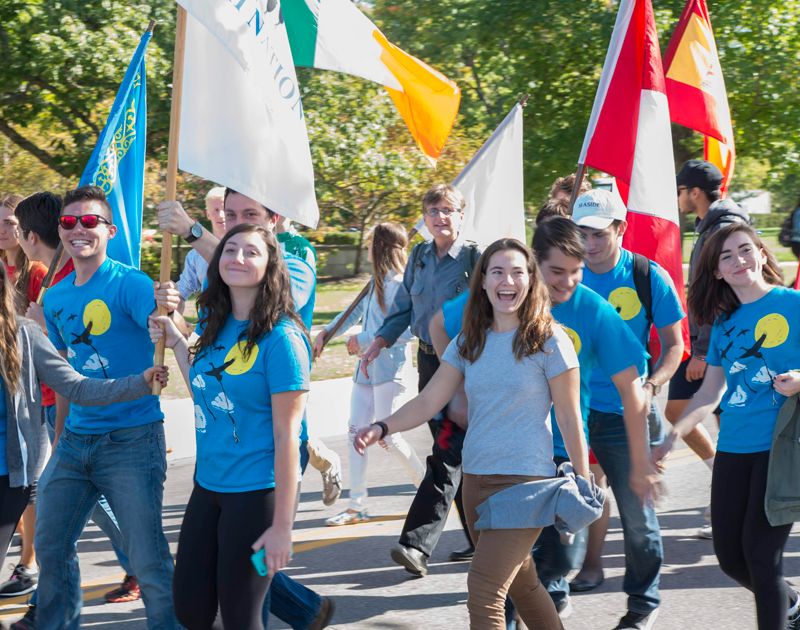 a parade of the miami community holding myaamia flags and imagery