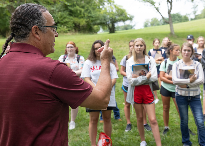 a person speaking to a group of people outdoors