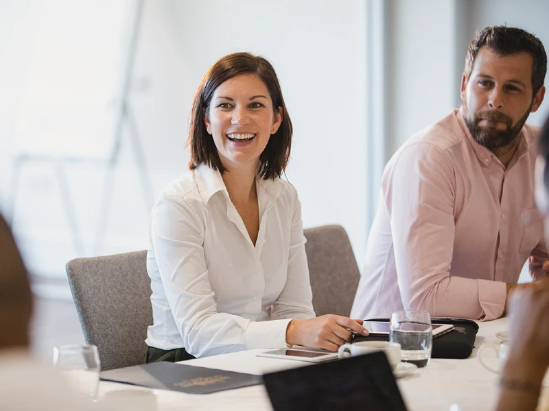 Woman sitting at conference table leading a meeting.