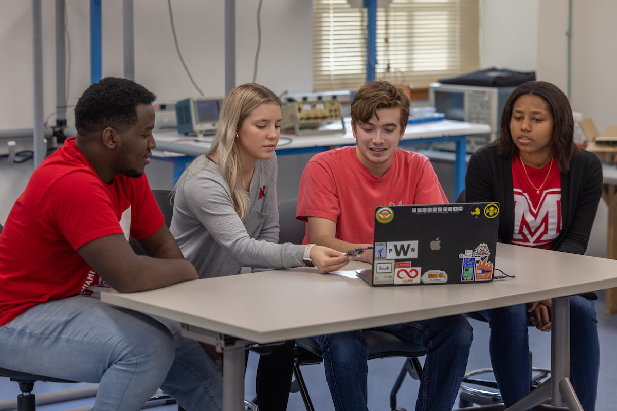 A group of students working together with laptop.