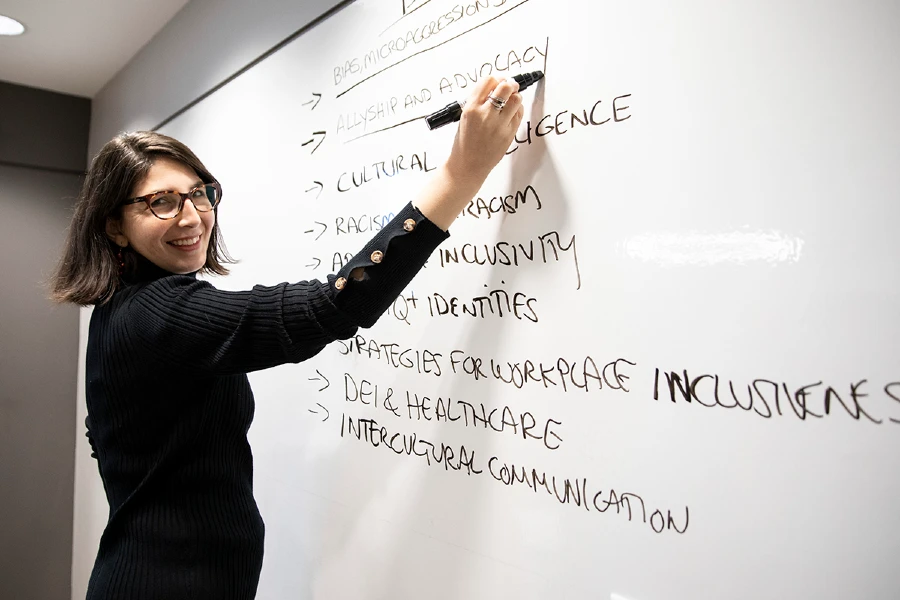 Cristina Alcade standing at white board.