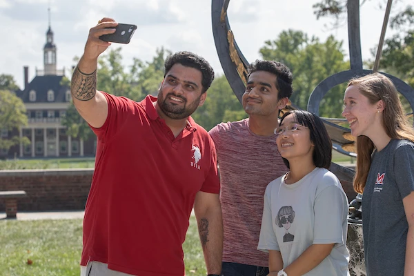 International students at sundial taking a selfie.