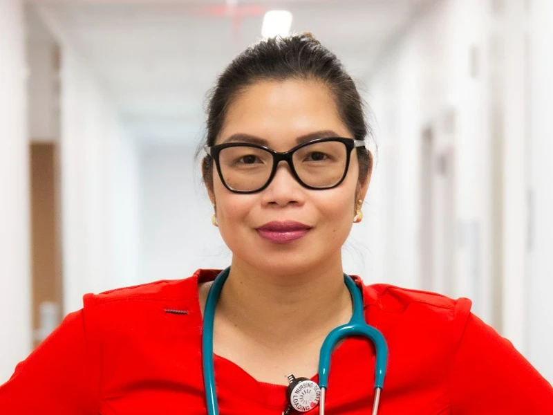 Nursing student wearing red scrubs and stethoscope.