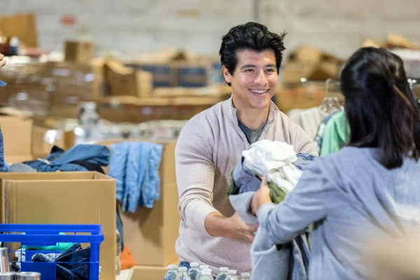 smiling man handing items to patrons