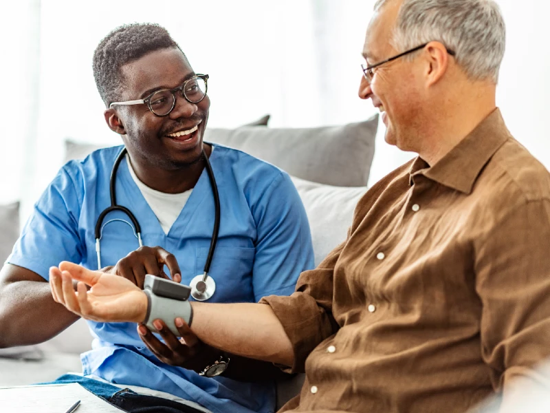 A smiling male student working with a patient.