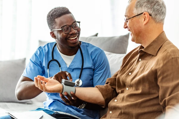 MSN-MBA Dual Degree student checking a wrist monitor with a patient. 