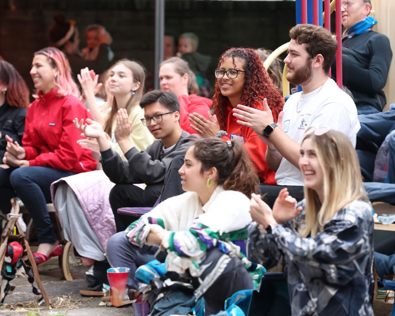 A group of student teachers at festival sitting on bleachers.