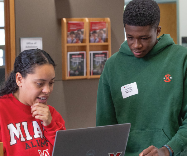 An admission counselor working with a student to complete their admission application.