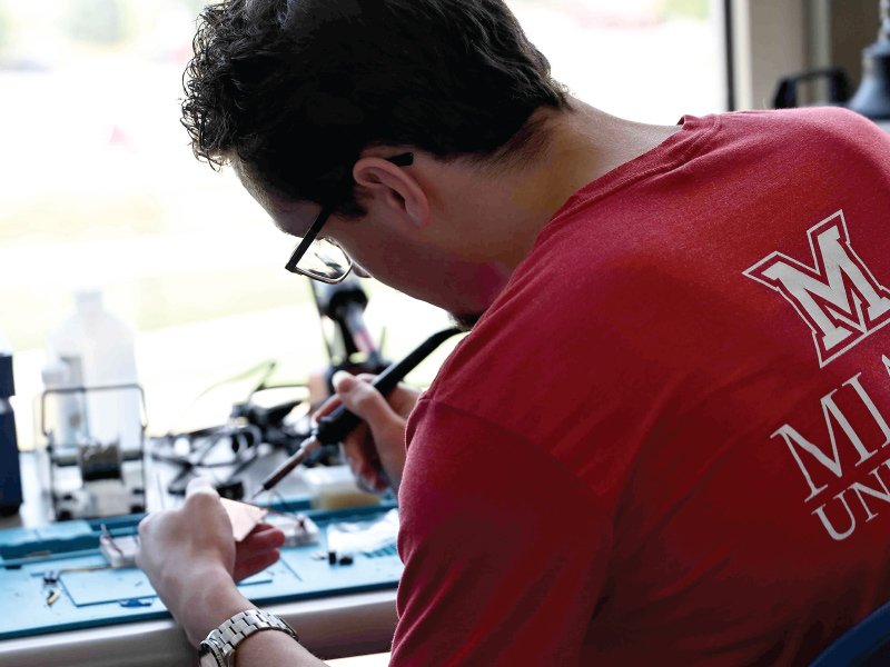 A engineering student using electrical tools.