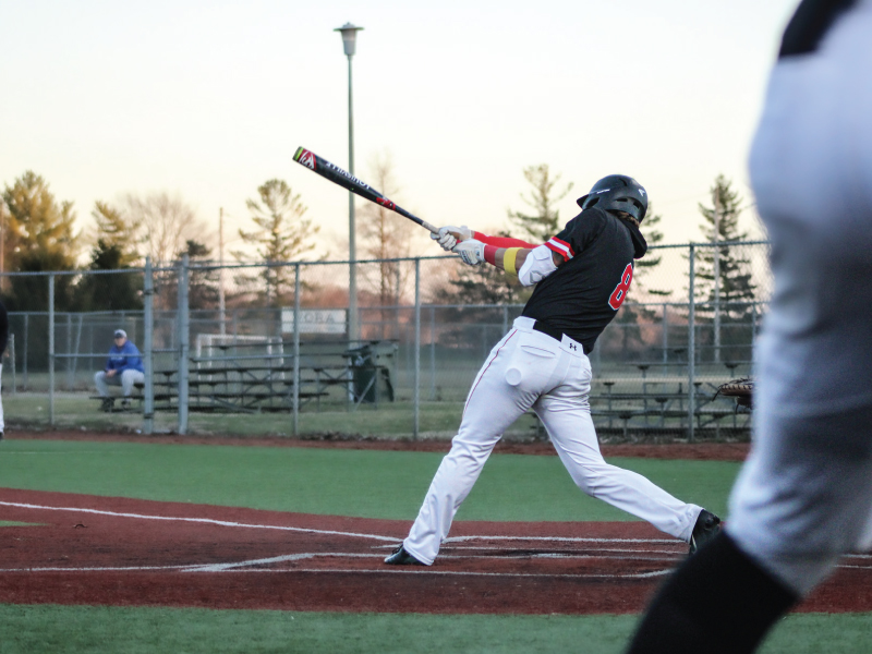 Miami Hamilton baseball swinging his bat at a pitch.