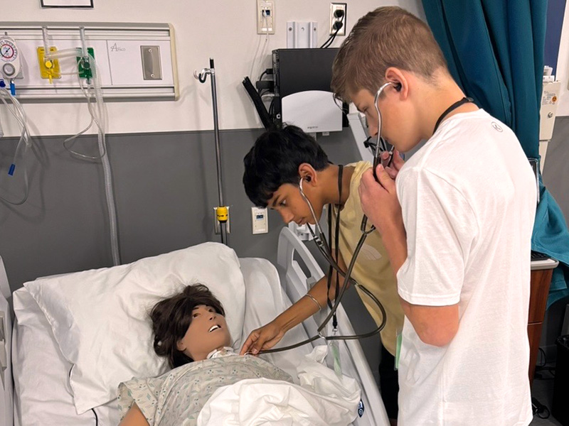 STEAM camper practicing CPR on a medical manikin