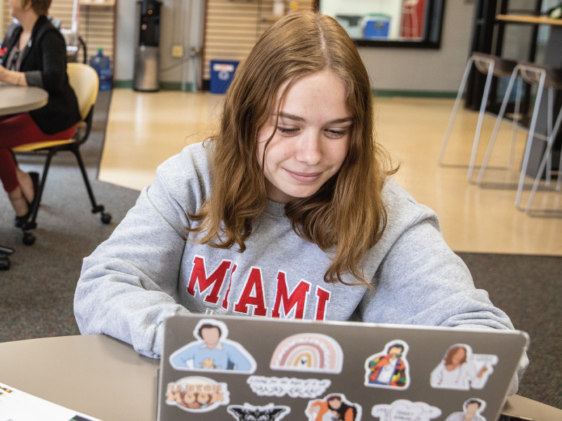 Student working on her laptop in the Diversity office.