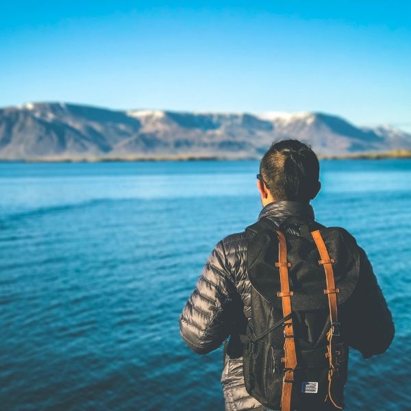 A student looking at a lake over an ocean. 