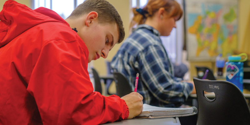 A student taking notes during class. 