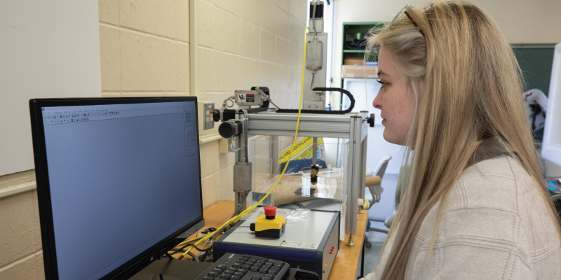 A female student using a engineering computer program.