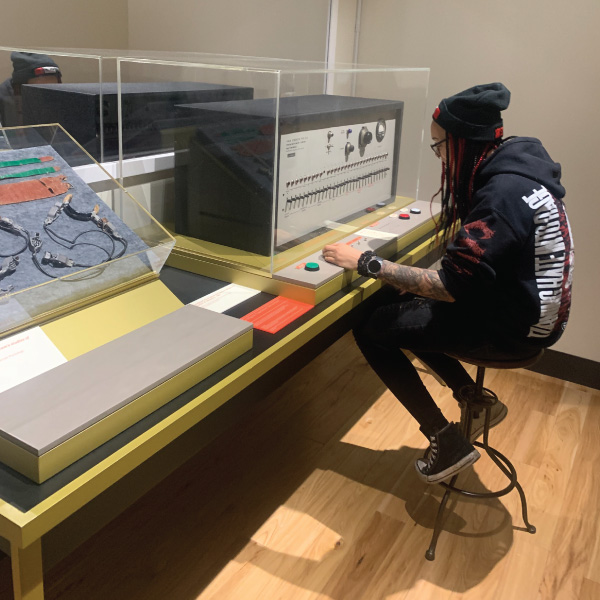 Student at the museum looking at a sound board.