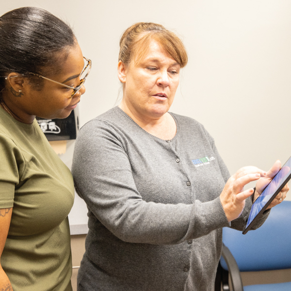 Brandi Brewer with a patient showing her something on an ipad