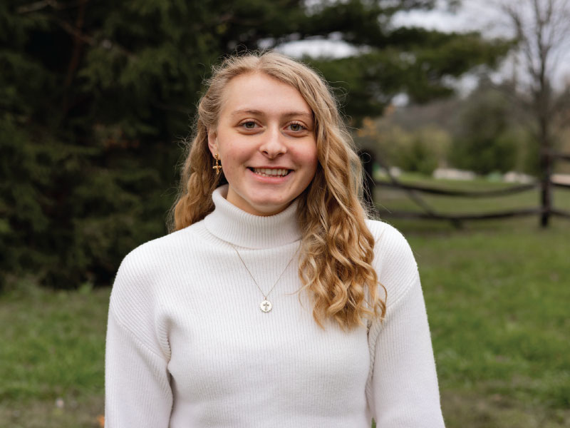 Tiffany S. smiling in a white sweater