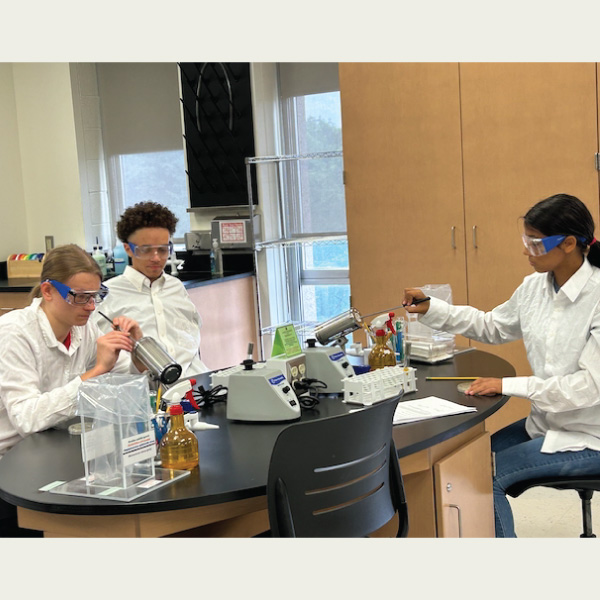 Students in white lab coats working in the science lab.