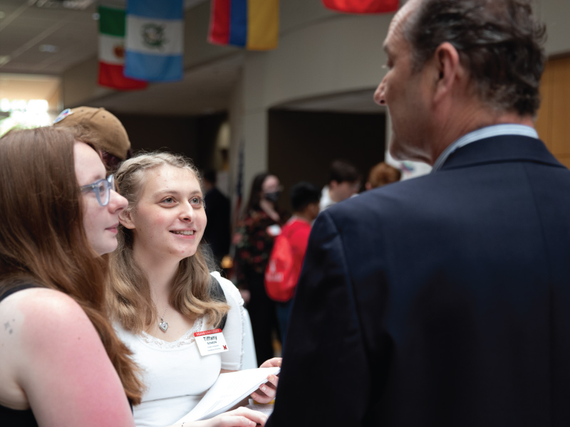 ENT student ambassadors talking to a community member at ENT senior design day