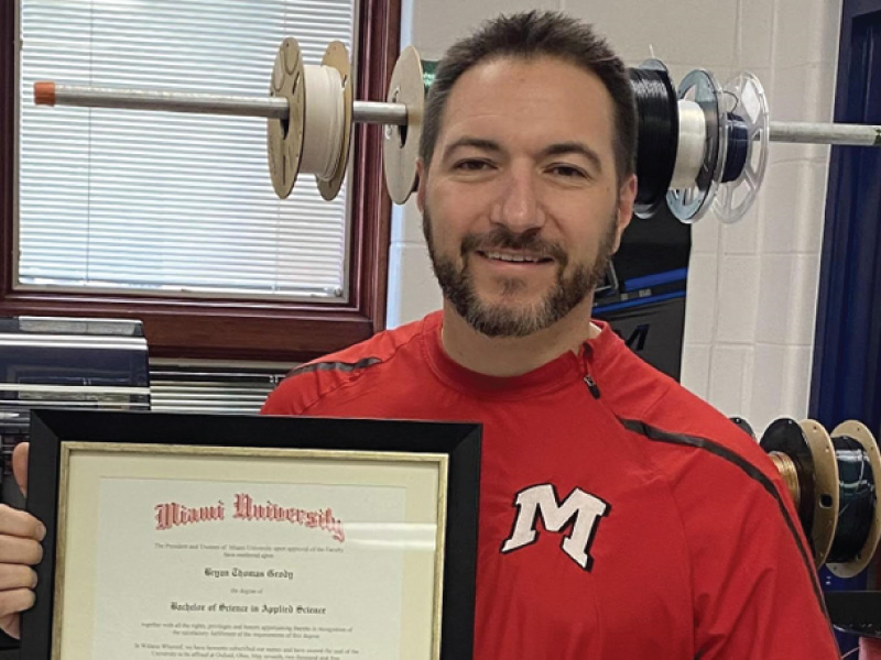 Bryan Grody holding his diploma.