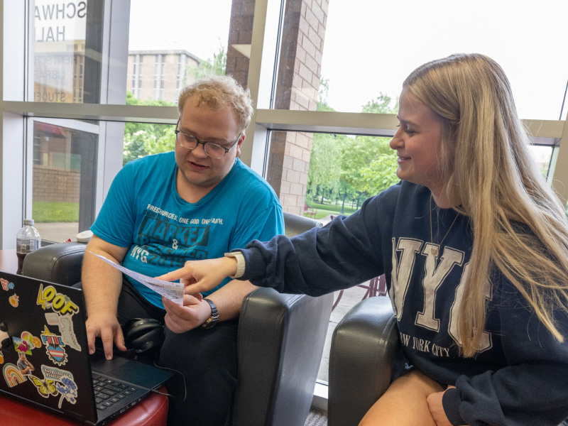 Student sitting in Schwarm commons looking at a laptop.