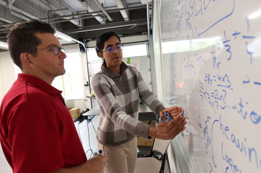 Mert Bal and Meena Narayan work in robotics lab.