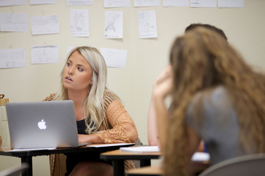 Student looks on in class with laptop.