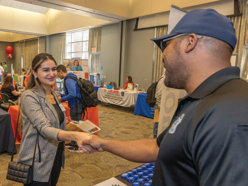 Student at the career fair on the Hamilton campus shaking an employers hand. 