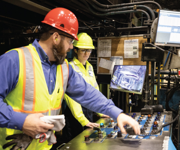 Student at Worthing Steel being shown how to work a piece of equipment with their supervisor. 