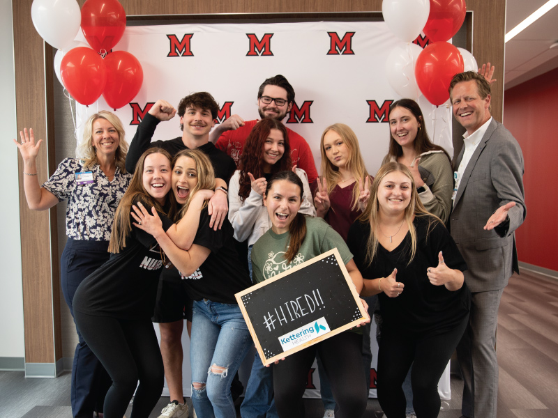 Group of nursing students holding a #Hired sign after being hired at Kettering Health
