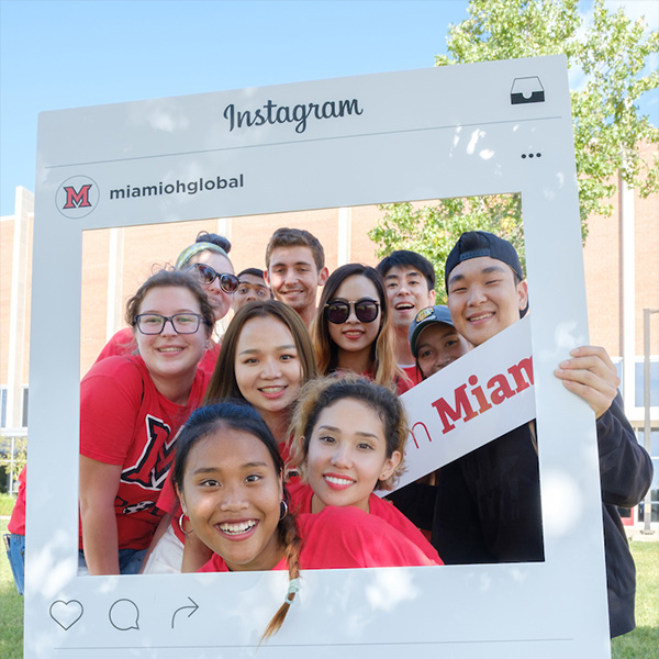 students posing in an instagram frame on campus