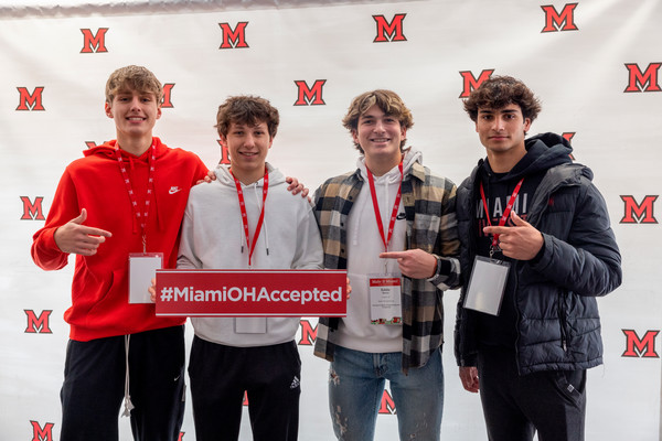 Four male students celebrating their admittance to Miami.