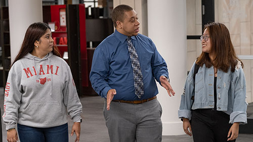 Two Miami students walking with a professor